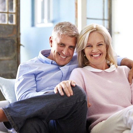 senior man and woman sitting together on couch