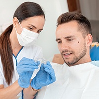 Dental assistant showing patient Invisalign aligner