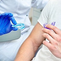 Dentist and patient holding mouthguards