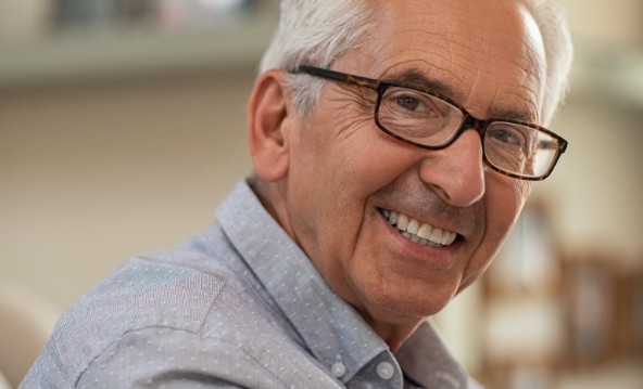 Man with flawless smile after replacing missing teeth