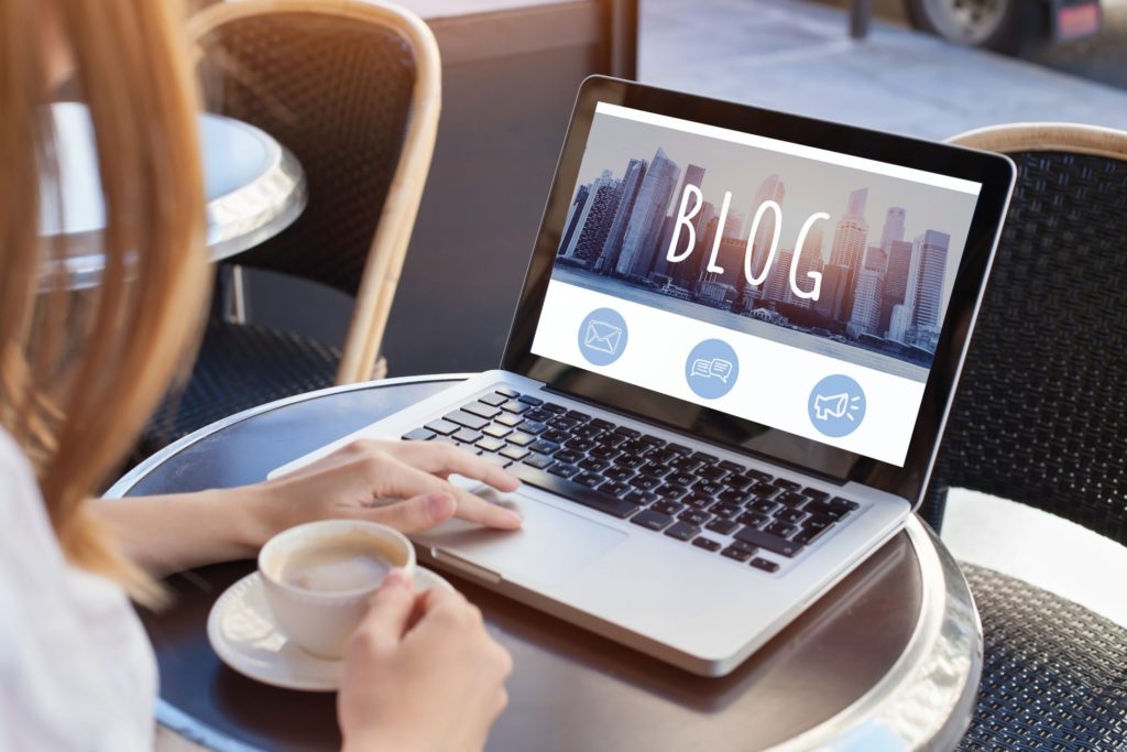 Woman drinking coffee and looking over new blog